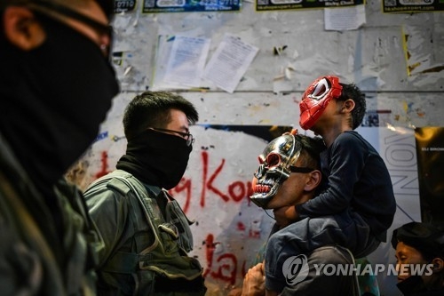 홍콩 경찰은 가면을 쓴 이들이 행진하는 곳에서 삼엄한 경비를 펼치며 이들이 정치적 구호를 외치는지 지켜봤다. 연합뉴스