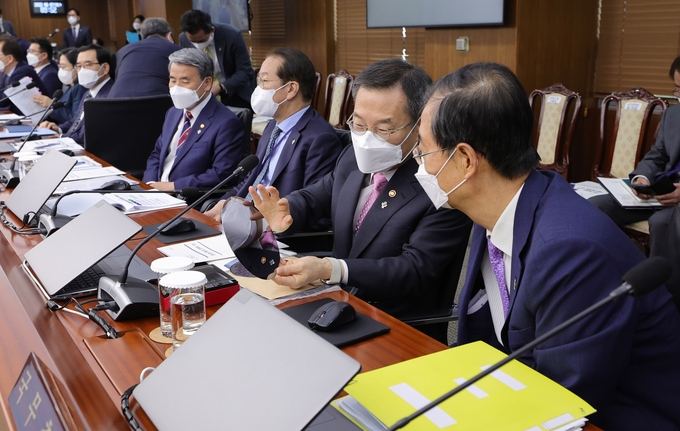 반도체 웨이퍼 보는 한덕수 국무총리 이종호 과학기술정보통신부 장관이 7일 용산 대통령실 청사 영상회의실에서 열린 국무회의에서 한덕수 국무총리에게 반도체 웨이퍼에 대해설명하고 있다. 
