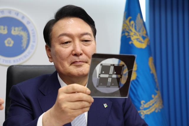 윤석열 대통령이 지난 7일 서울 용산 대통령실 청사에서 열린 국무회의에서 반도체 포토마스크를 보고 있는 모습. 대통령실 제공
