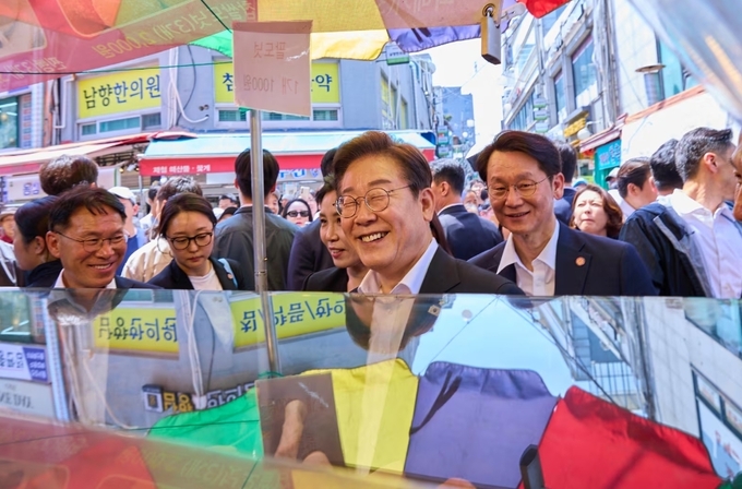 이재명 대통령과 김혜경 여사가 6일 서울 사당동 남성시장을 방문해 상인과 대화하고 있다. /대통령실