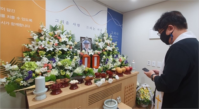 장애인으로 살았던 삶을 마감한 무연고 사망자의 장례에서 추도문을 읽고 있다